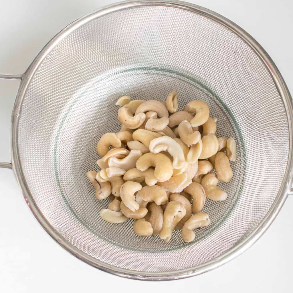 drained cashew nuts in a colander.
