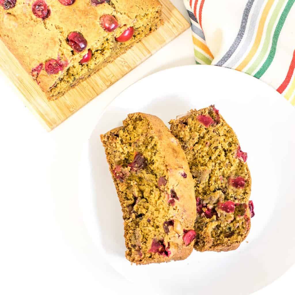top view of sliced vegan cranberry orange bread on a serving plate. 