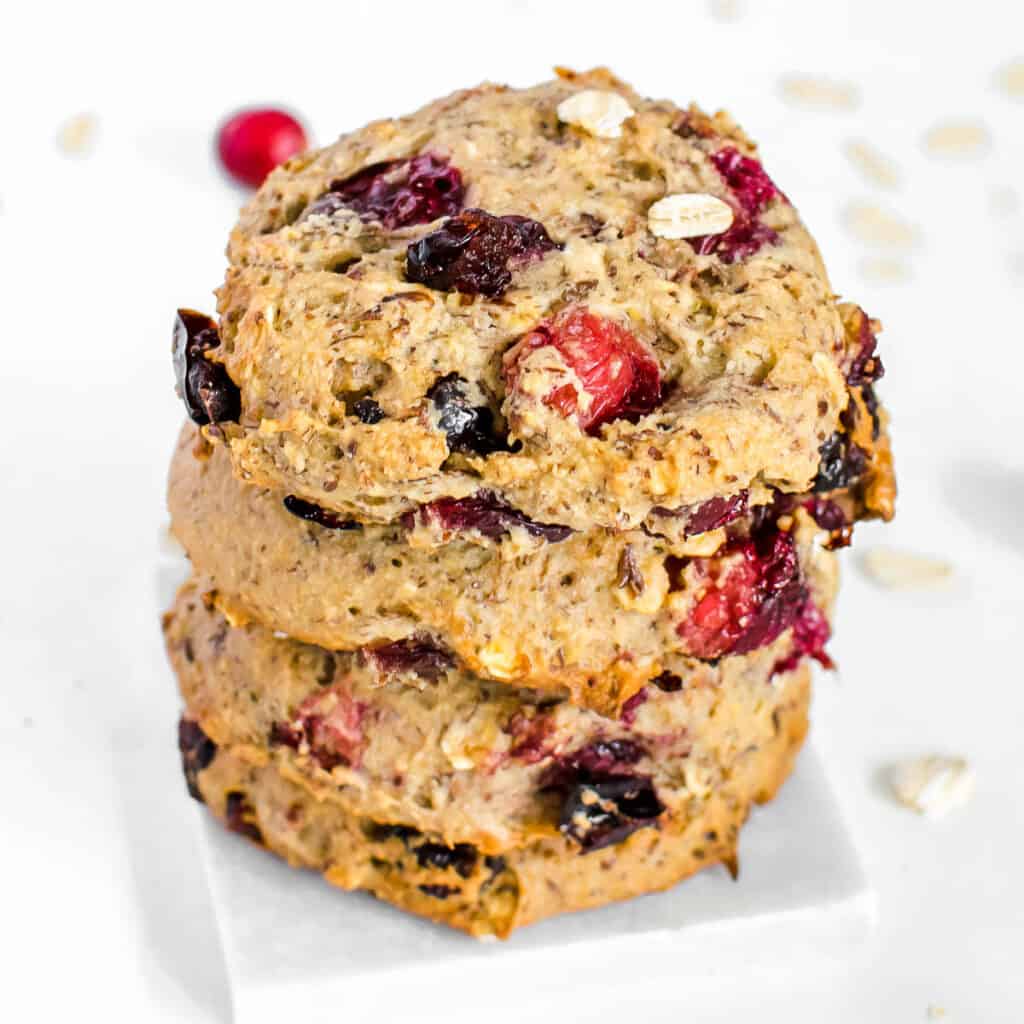 a 45 degree angle view of stacked vegan oatmeal cranberry cookies.