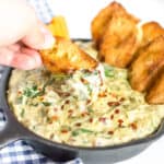 baguette scooping through vegan spinach artichoke dip