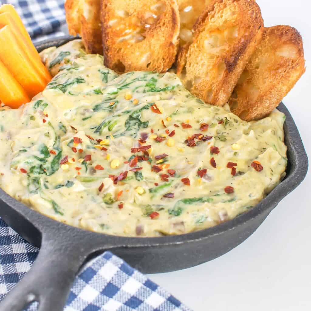 a 45 degree angle view of vegan spinach artichoke dip. 