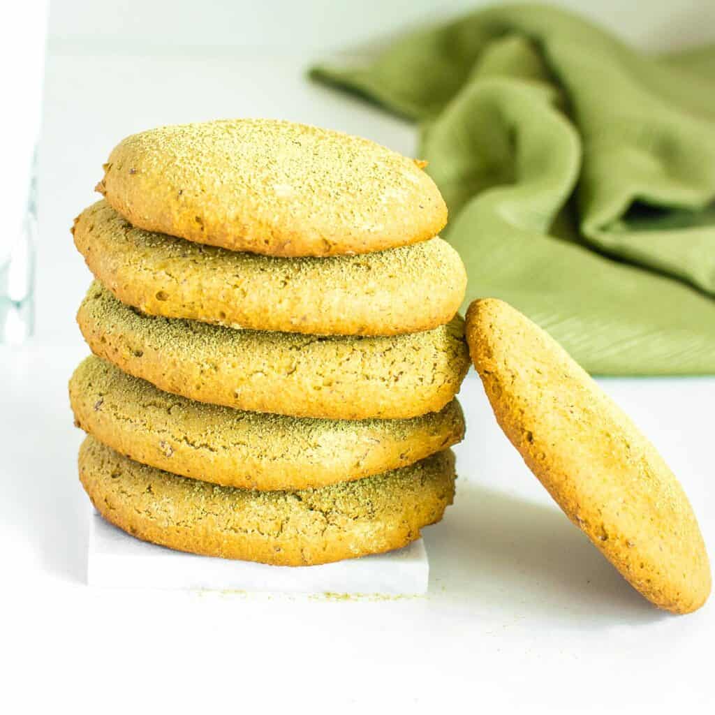 stacked matcha cookies with one of them on the side.