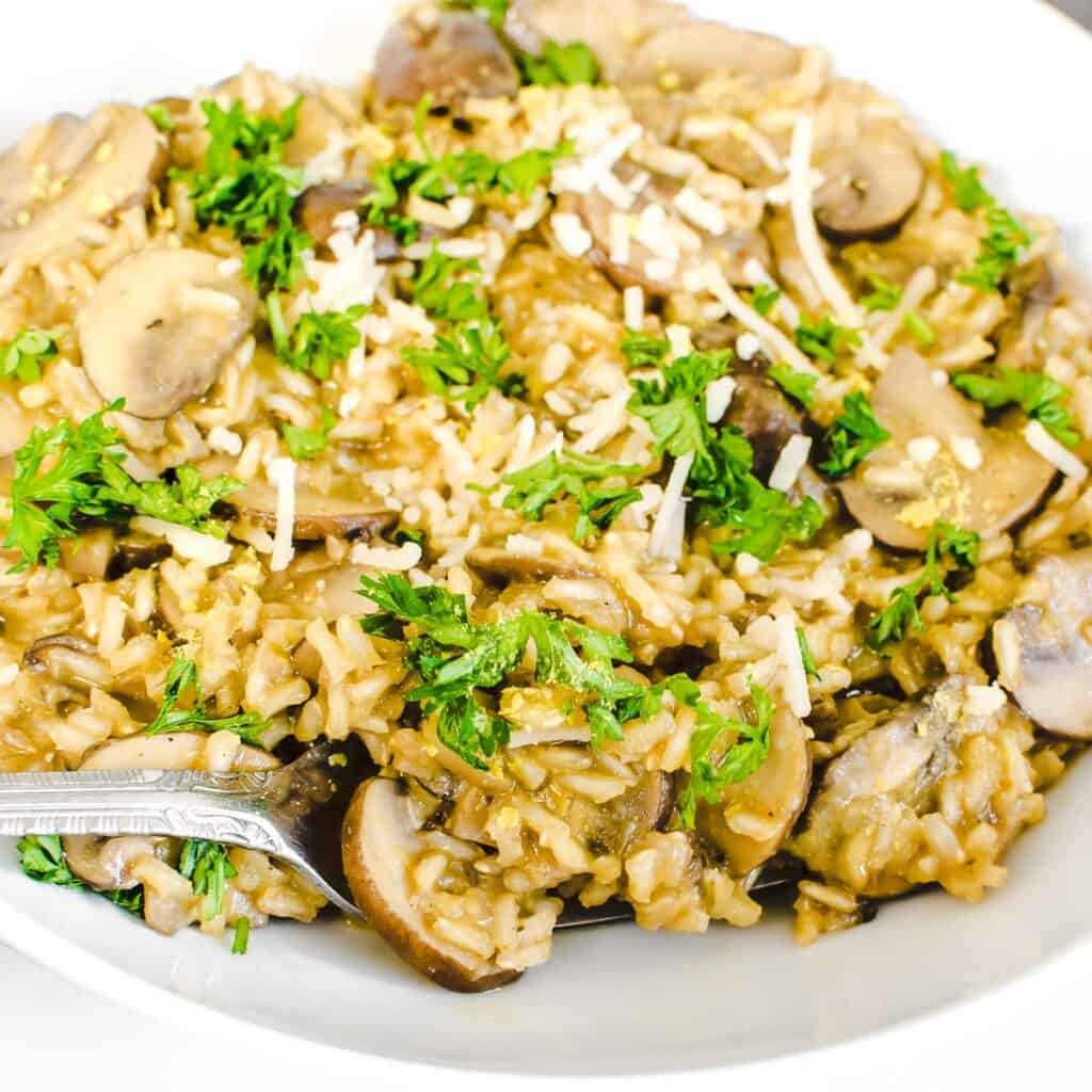 a fork digging into brown rice mushroom risotto