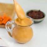 vegan chipotle mayo dripping form a spoon to its jar.