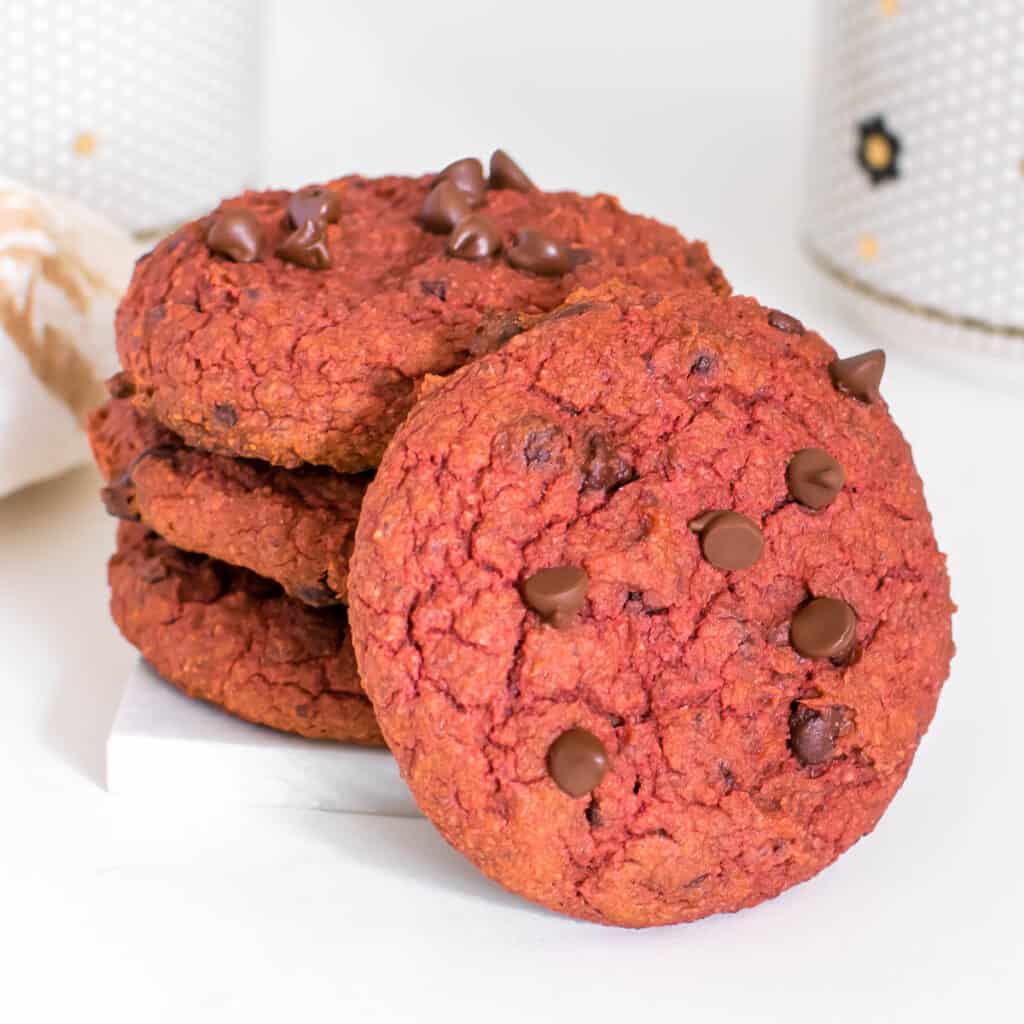 stacked vegan red velvet cookies supporting one cookie in the from with a focus.