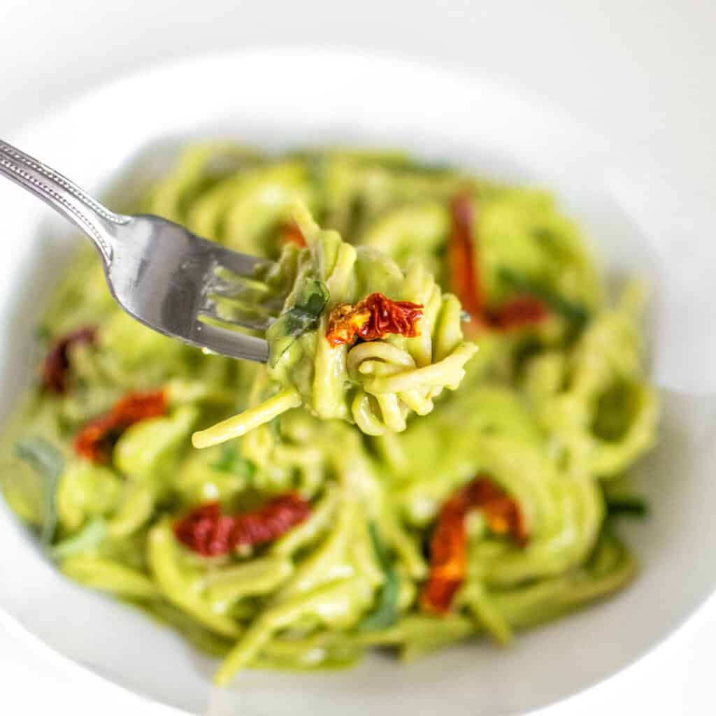 vegan avocado pasta being picked up by a fork. 