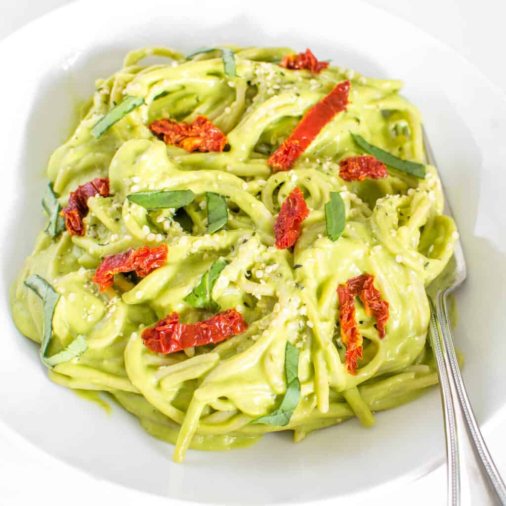 a 45 degree angle view of served vegan avocado pasta.