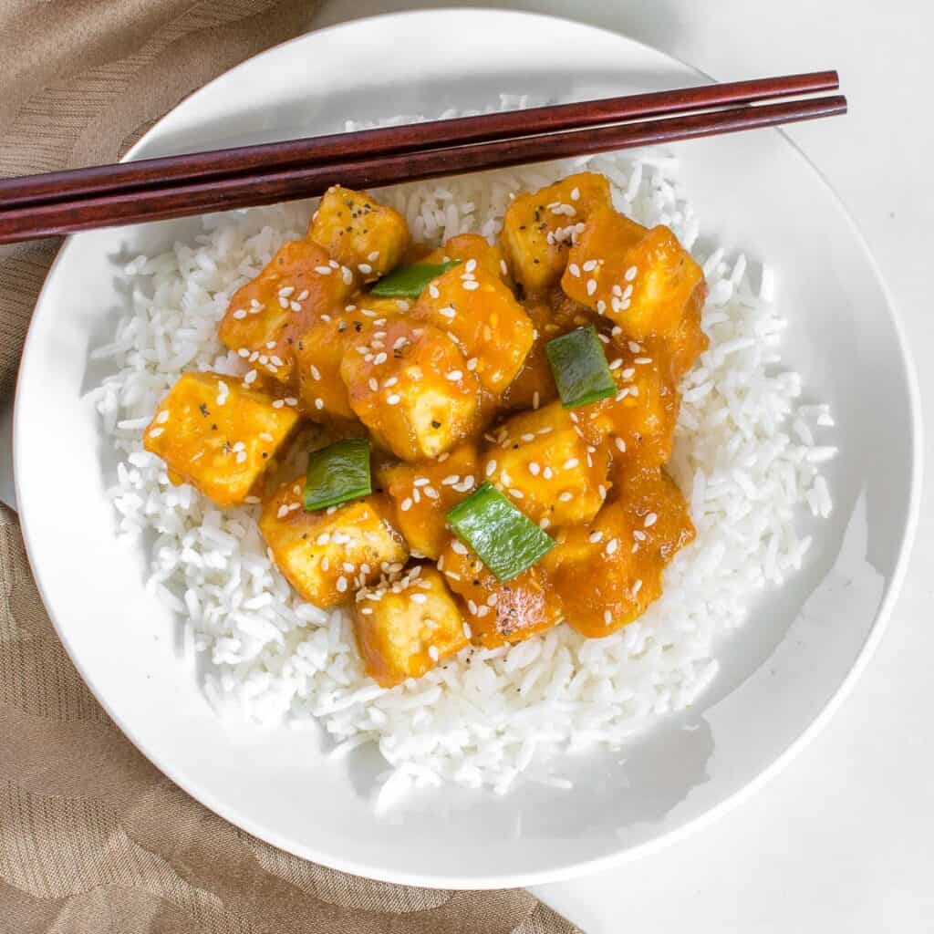 top view of served orange tofu on the bed of rice. 