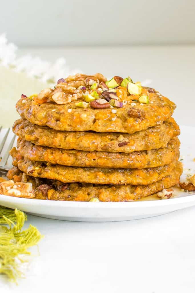 a tall tower of stacked vegan carrot cake pancakes.