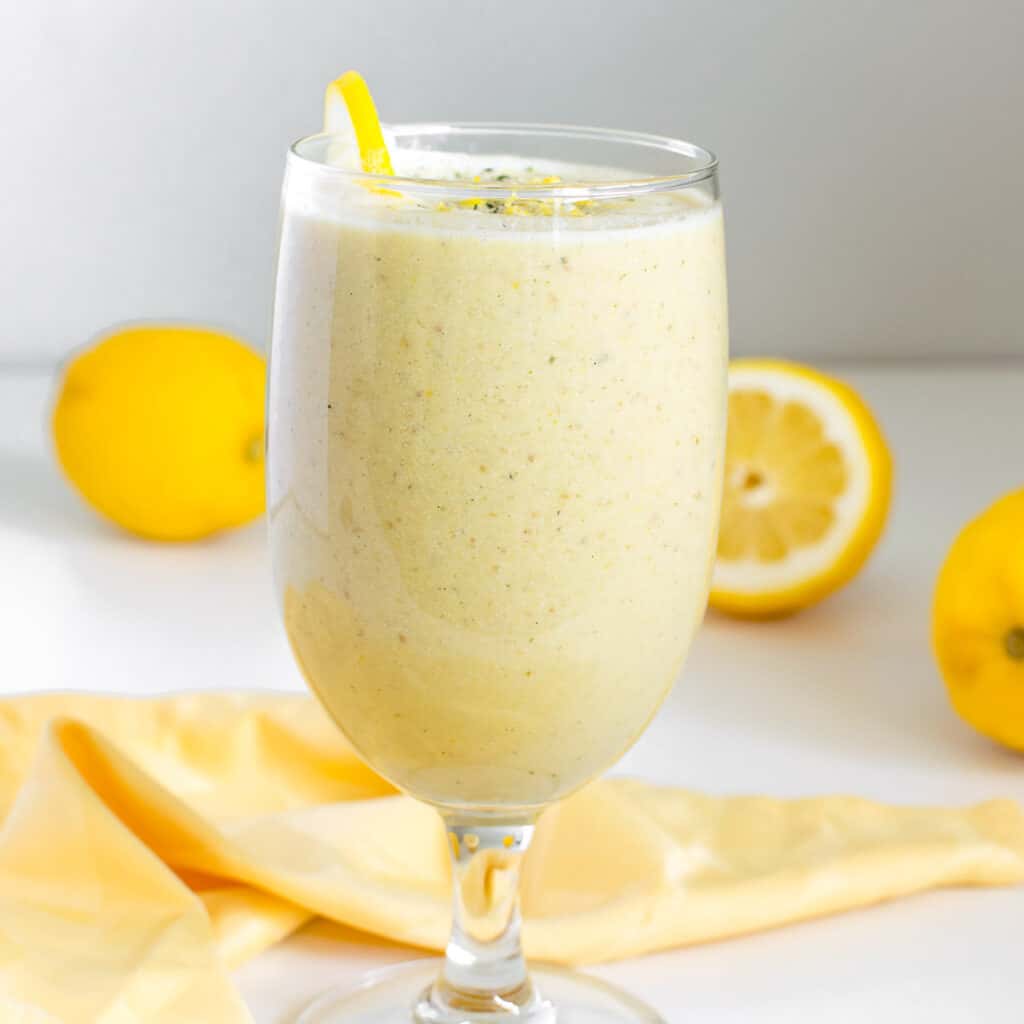 front view of  a tall glass filled with lemon smoothie.