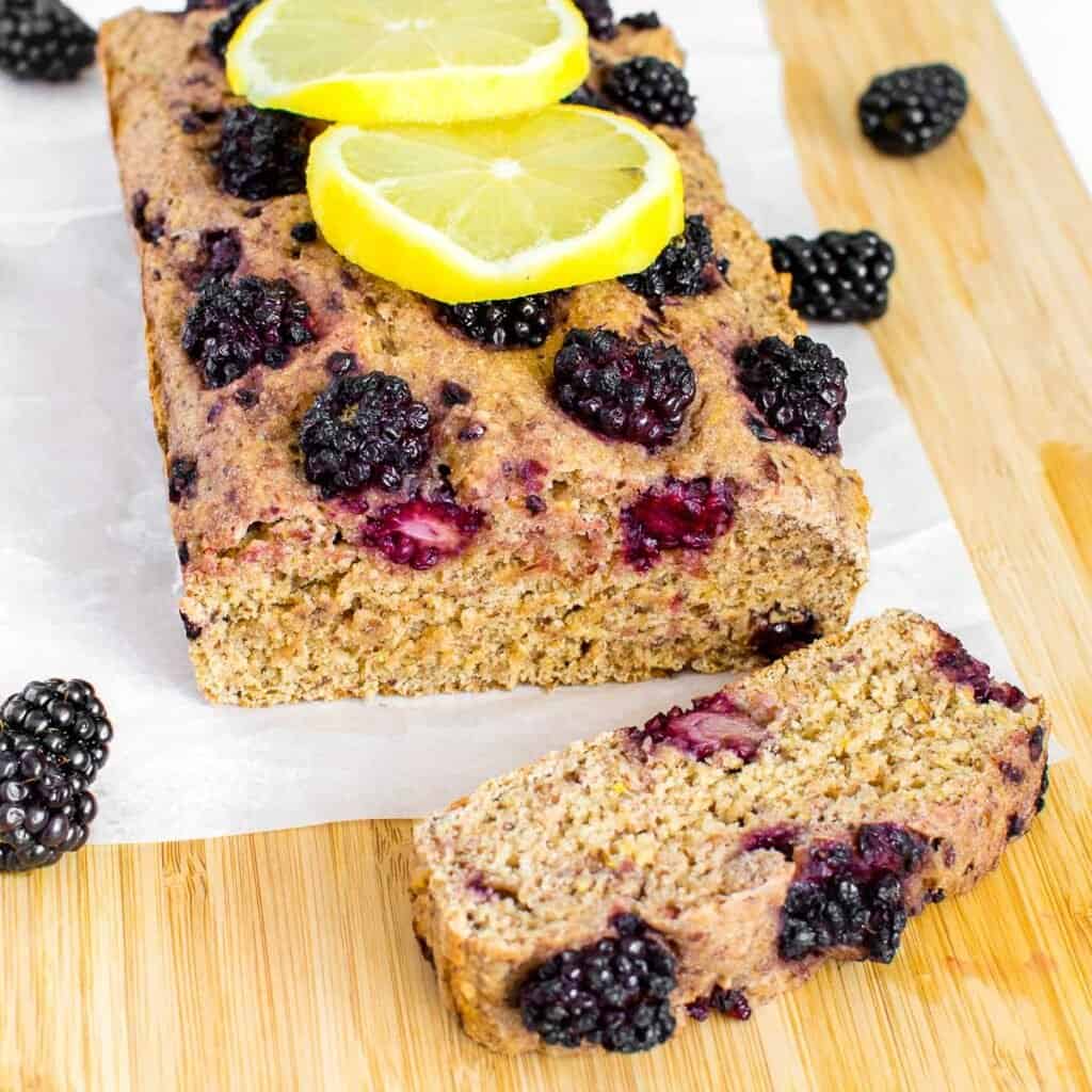 45 degree angle view of blackberry lemon bread with its slice on a side.