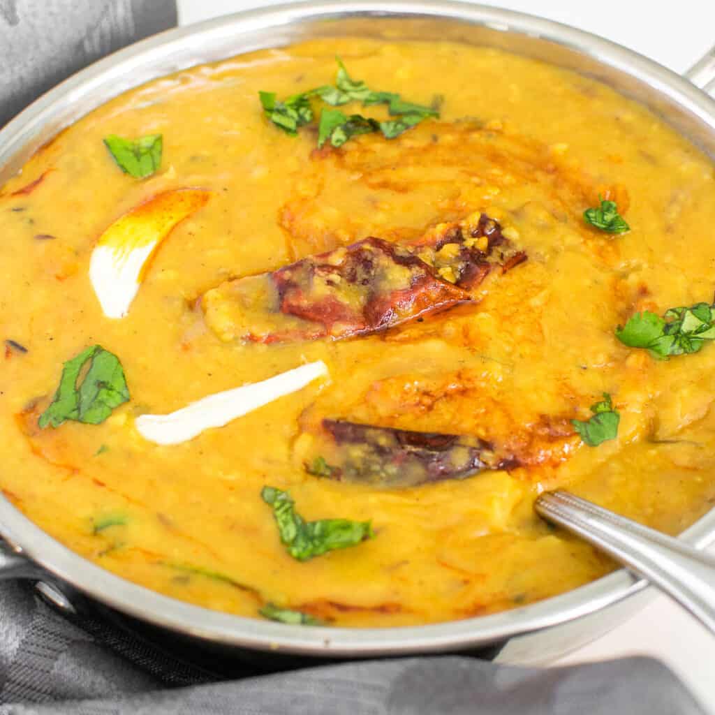a close up view of dal tadka served in a kadhai.