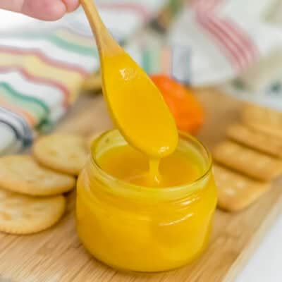 pineapple habanero sauce dripping from a spoon into the jar.
