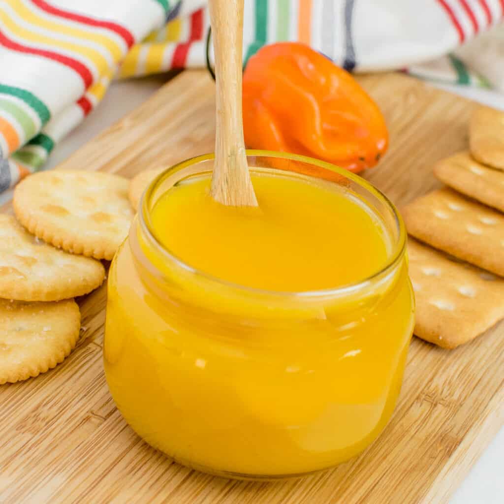 a front view of a jar filled with pineapple habanero sauce. 