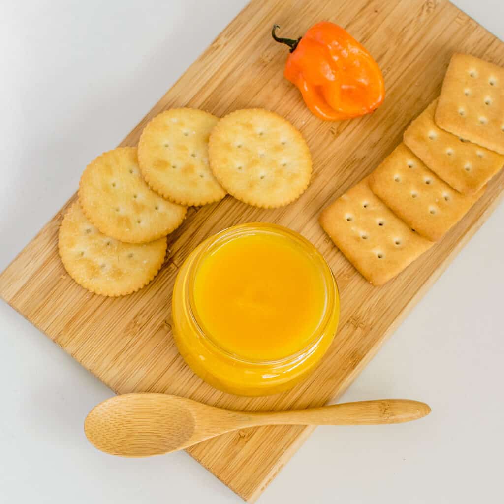 top view of served pineapple habanero sauce with crackers. 