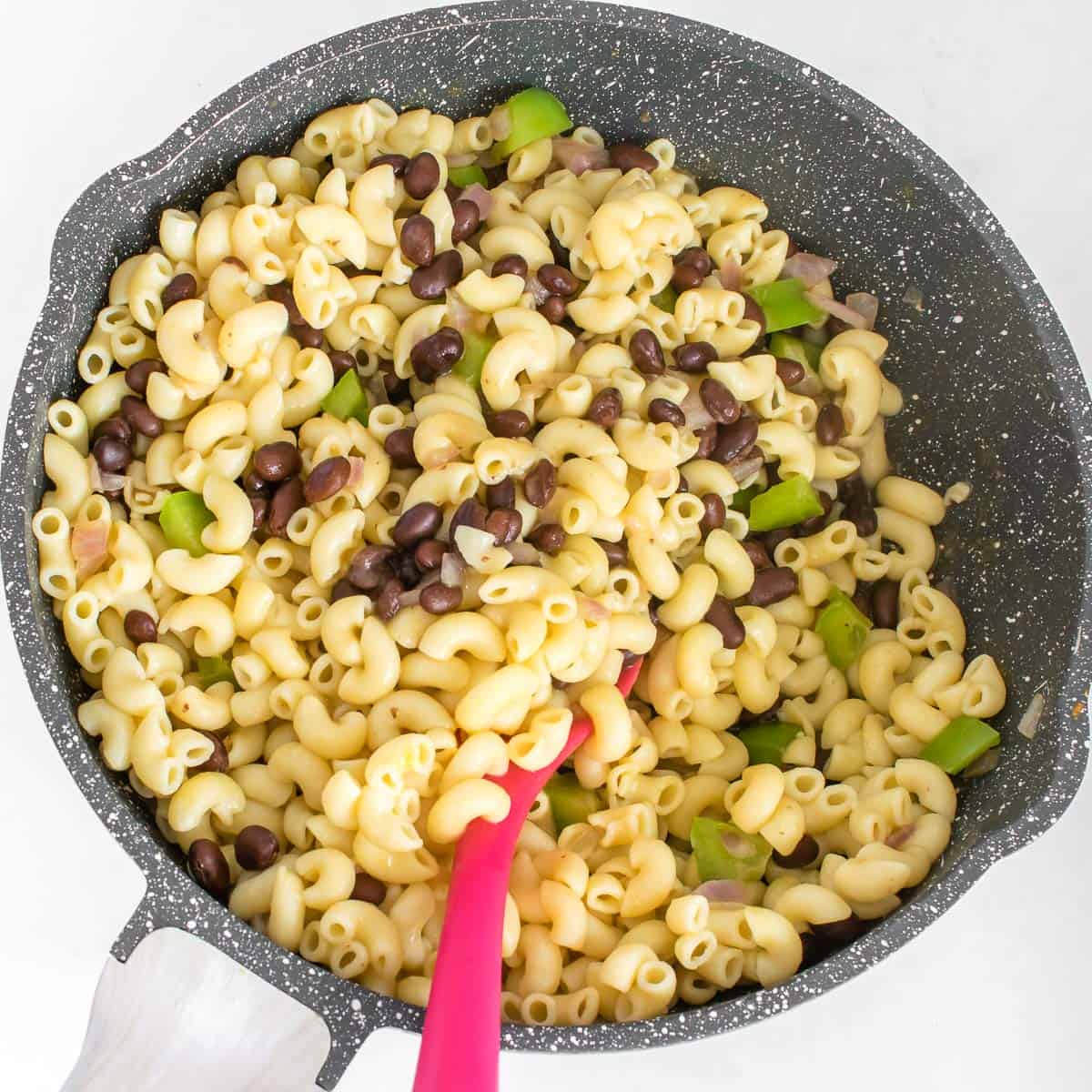 cooked pasta in the pan along with veggies and beans.