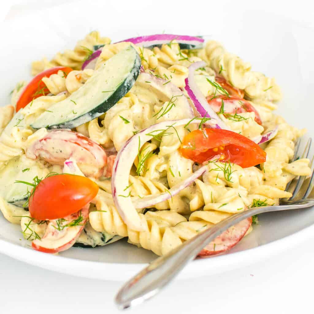 a close up view of tomato cucumber pasta salad.