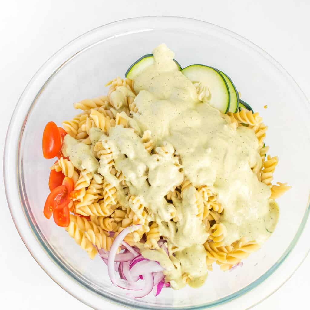 drizzled dressing over tomato and cucumber pasta salad.