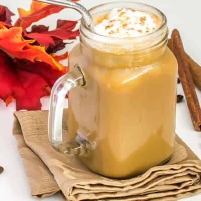 a full view of a glass filled with iced pumpkin latte.