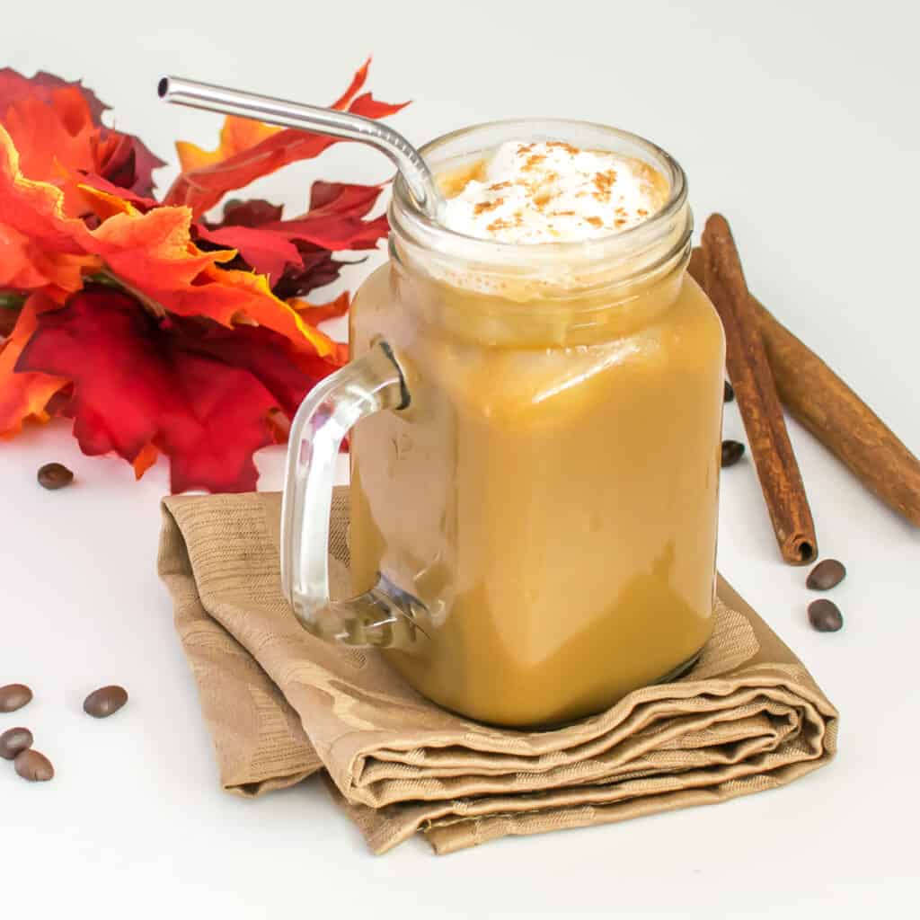 a full view of a glass filled with iced pumpkin latte.