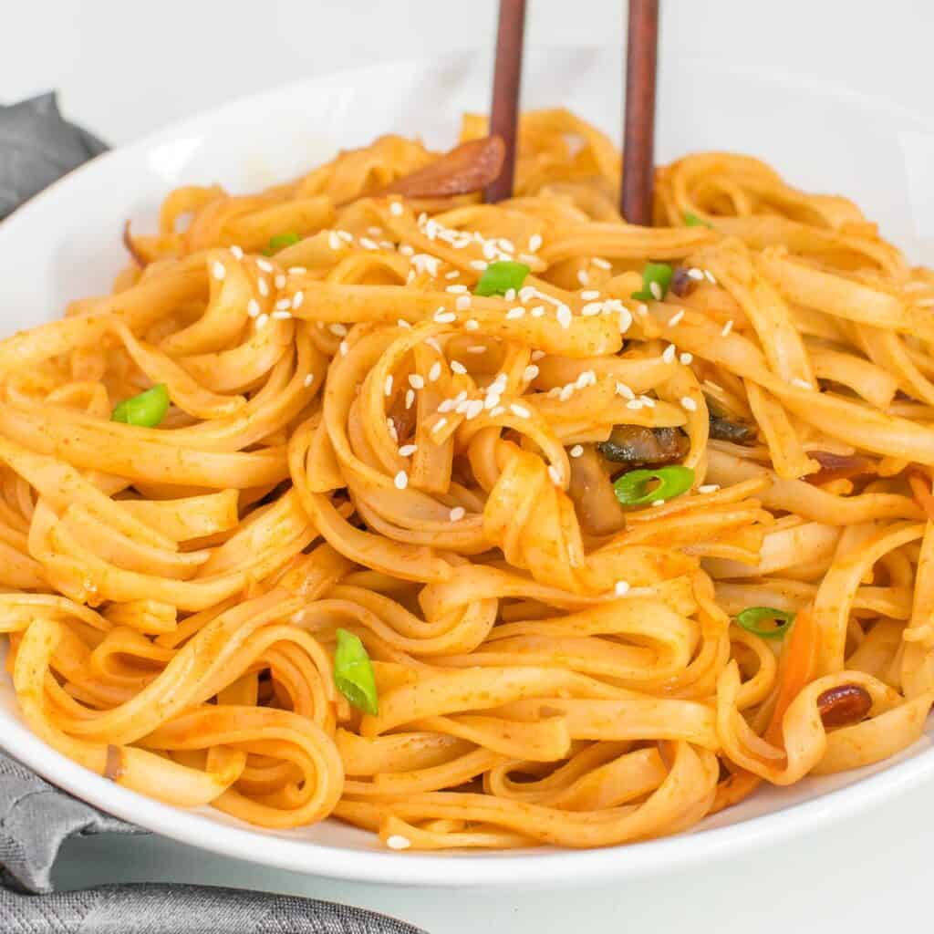 chopsticks inserted into served gochujang noodles.