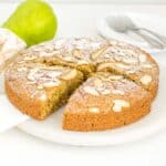 A 30 degree anlge view of vegan pear cake being sliced.