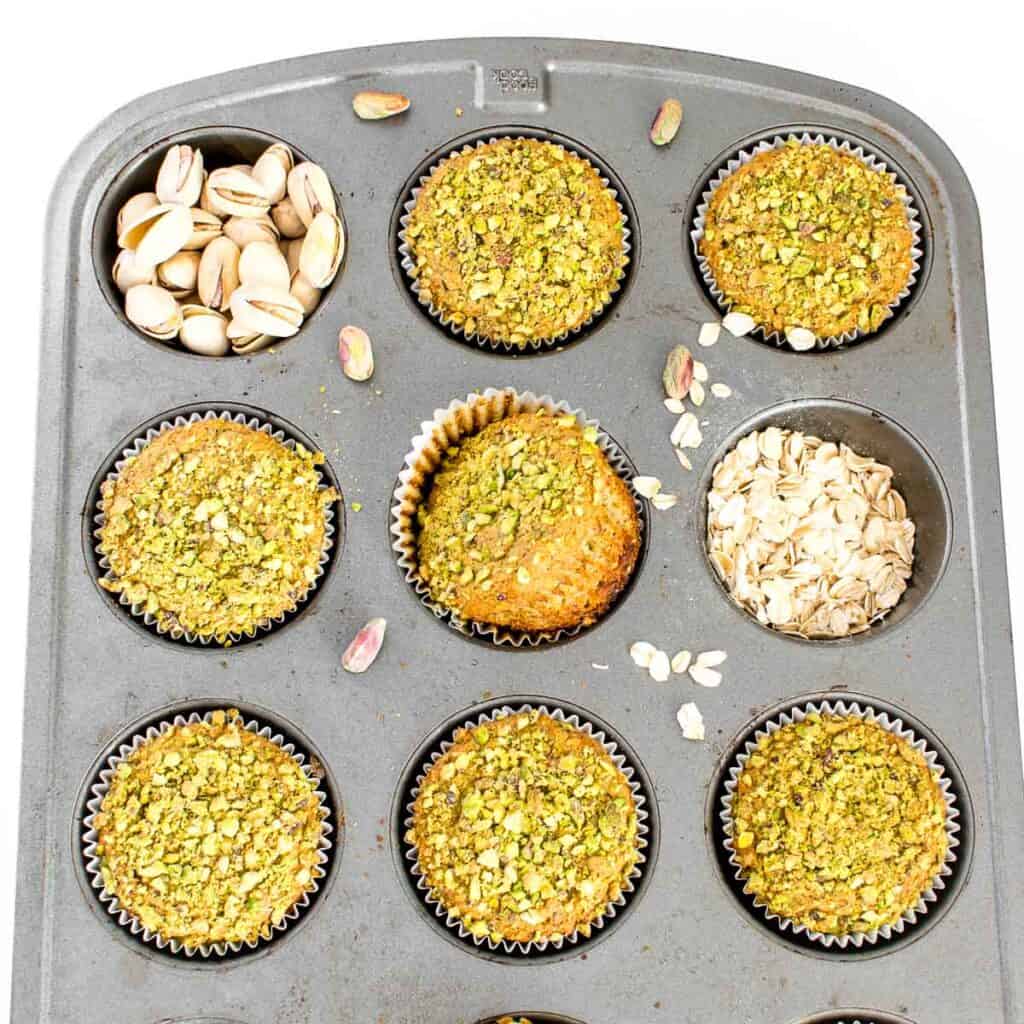 raw pistachios and oats along with pistachio muffins in the muffin tray. 