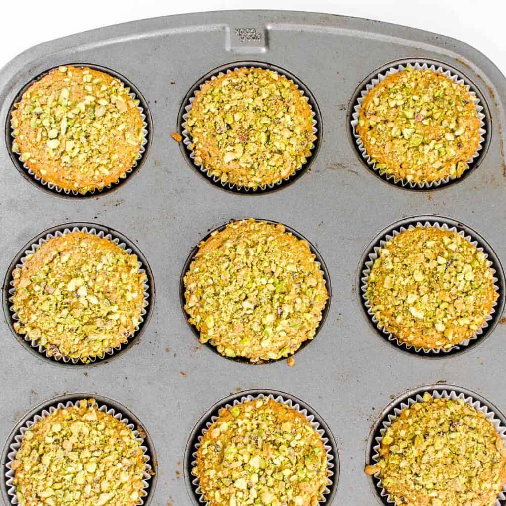 fresh baked pistachio muffins in the muffin tray cooling down. 