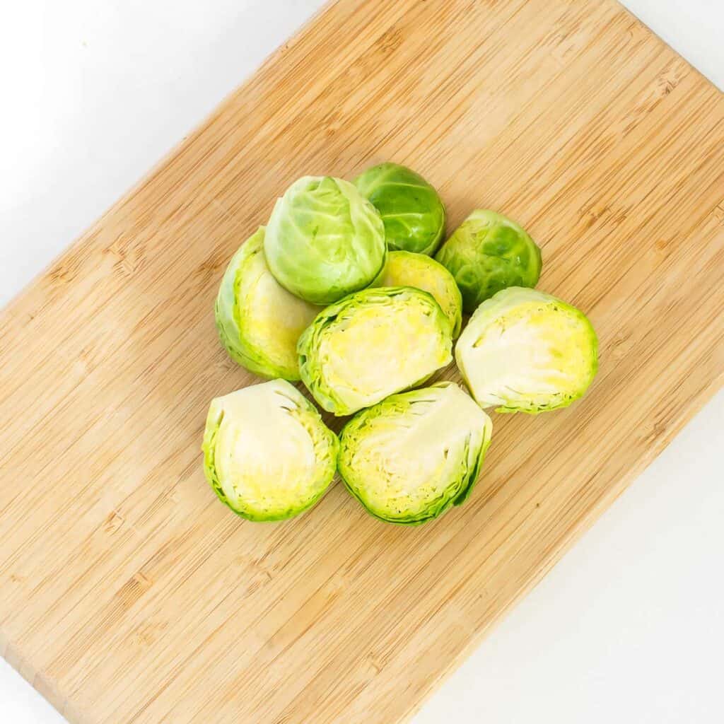 halved brussels sprouts on a wooden board. 