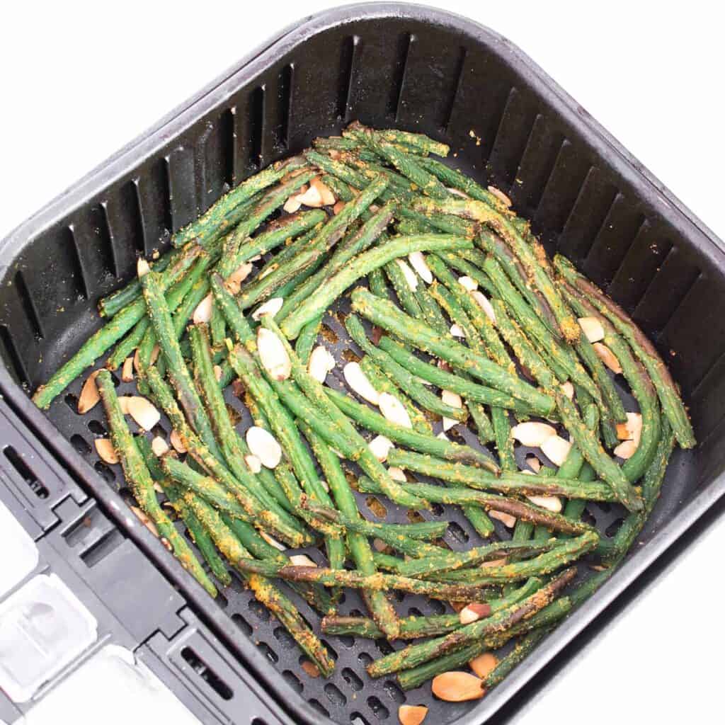 air fried green beans in the air fryer basket.