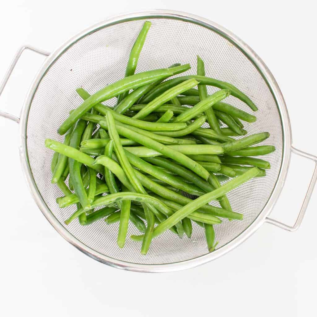 raw green beans in a colander.