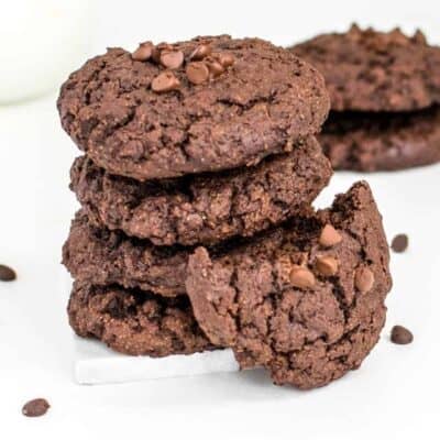vegan chocolate cookies stacked with a half eaten cookie with a focus.