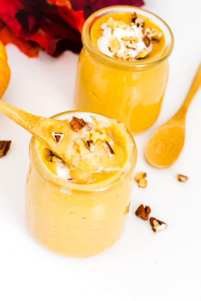 a spoon digging into the glass jar of vegan pumpkin mousse. 