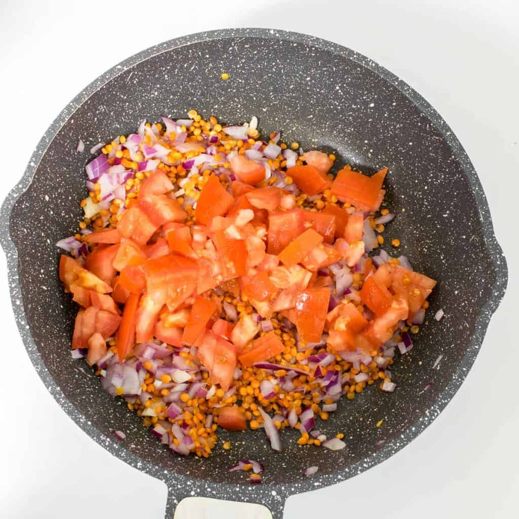 cooked tomatoes along with other ingredients in the pan. 