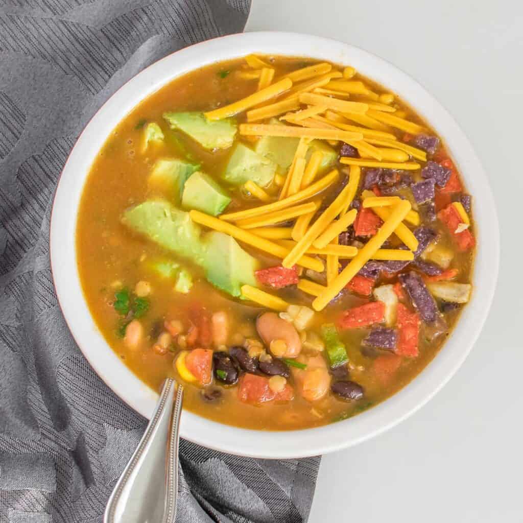 top view of served vegan taco soup with its garnishes. 