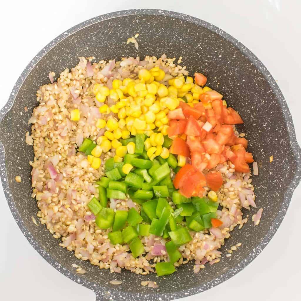 veggies tossed in the pan with other ingredients. 