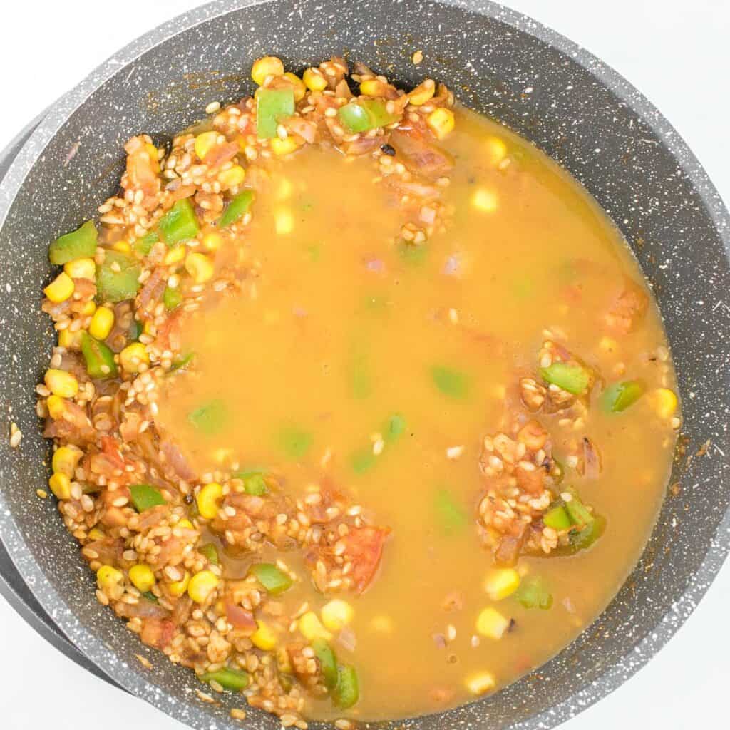 rice and veggies being cooked in the vegetable broth. 