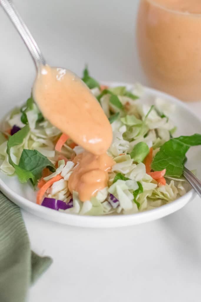 tofu dressing drizzling over a bowl of salad. 