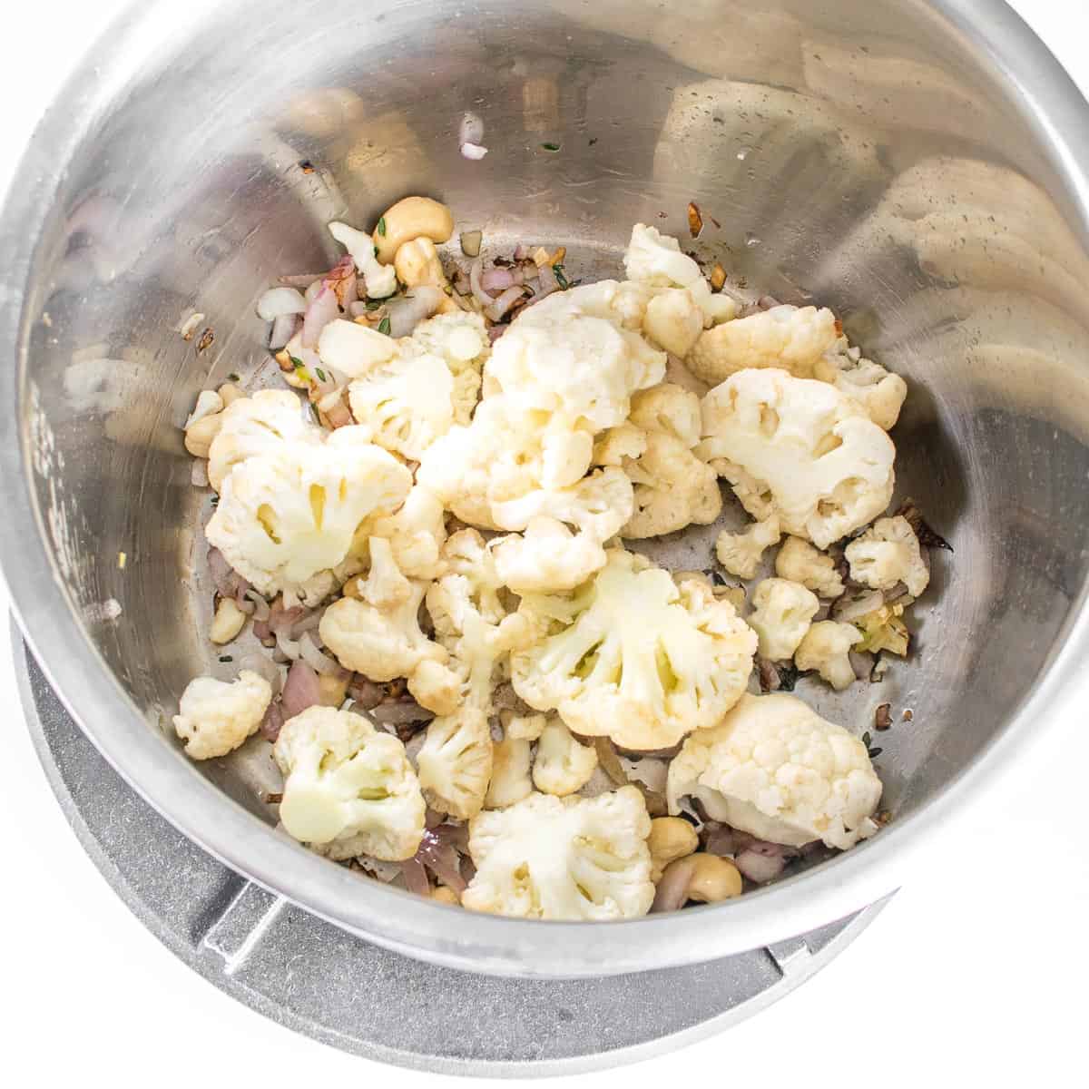 cauliflower being cooked with other ingredients in the instant pot. 