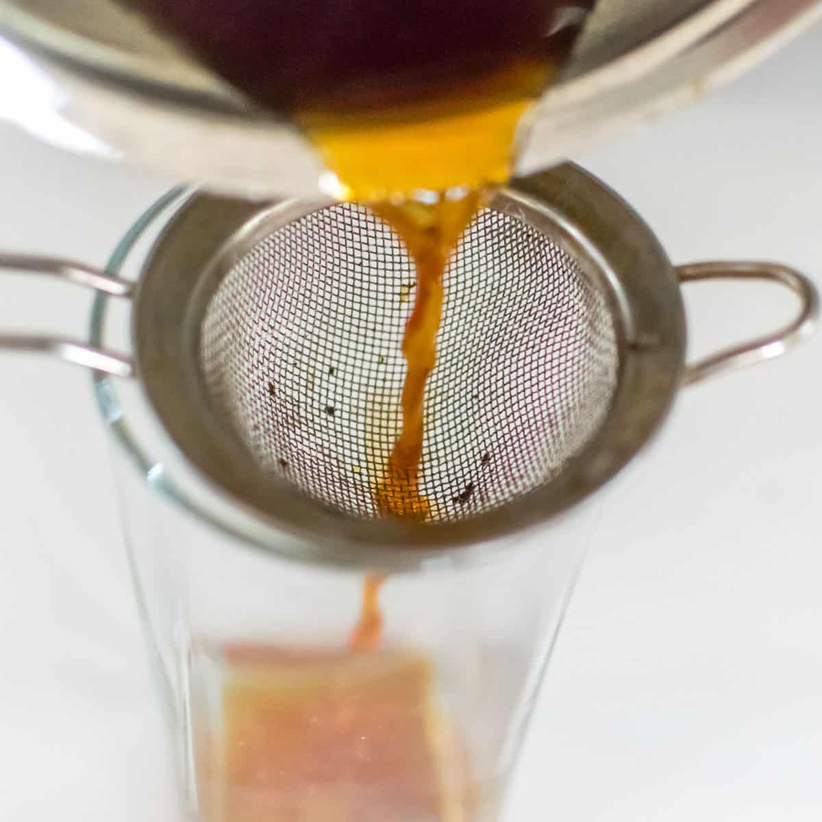 tea strained in the glass with the help of a strainer. 