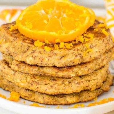 a 45 degree angle view of stacked orange pancakes.