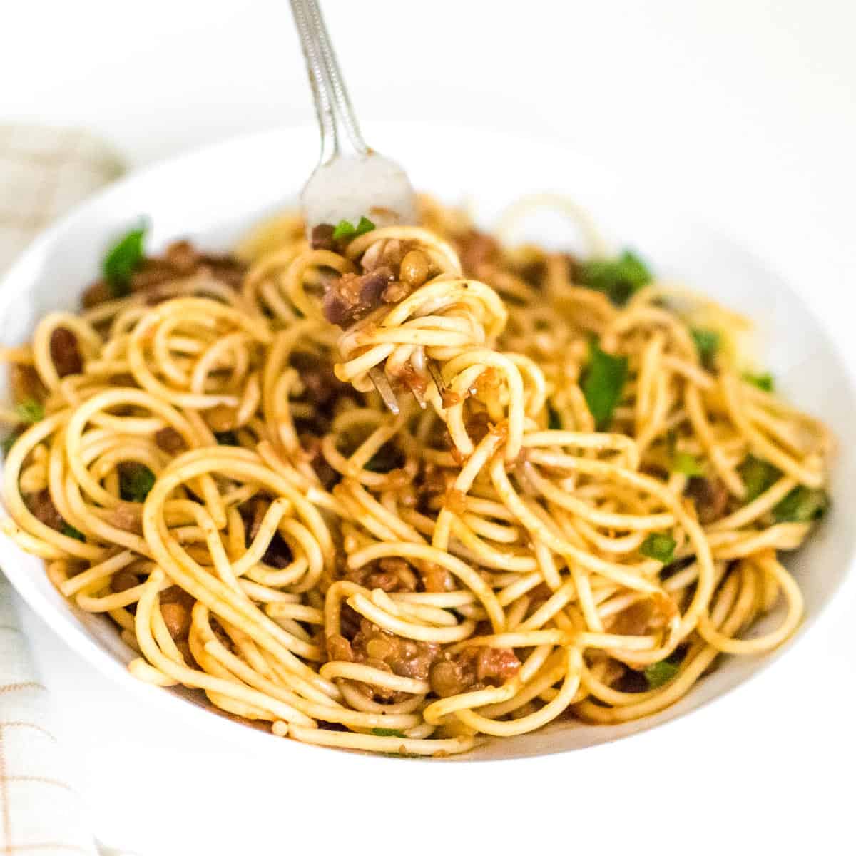 lentil Bolognese mixed in spaghetti and picked with a fork.