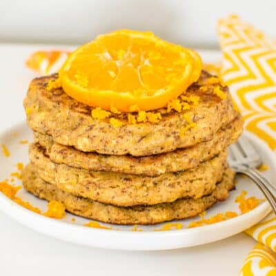 a 45 degree angle view of stacked orange pancakes.