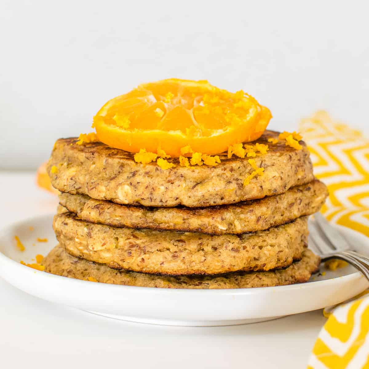a front view of stacked orange pancakes. 