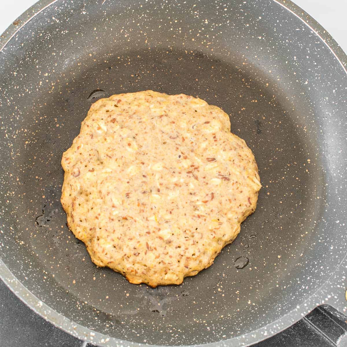 cooked batter in a pan forming a pancake. 