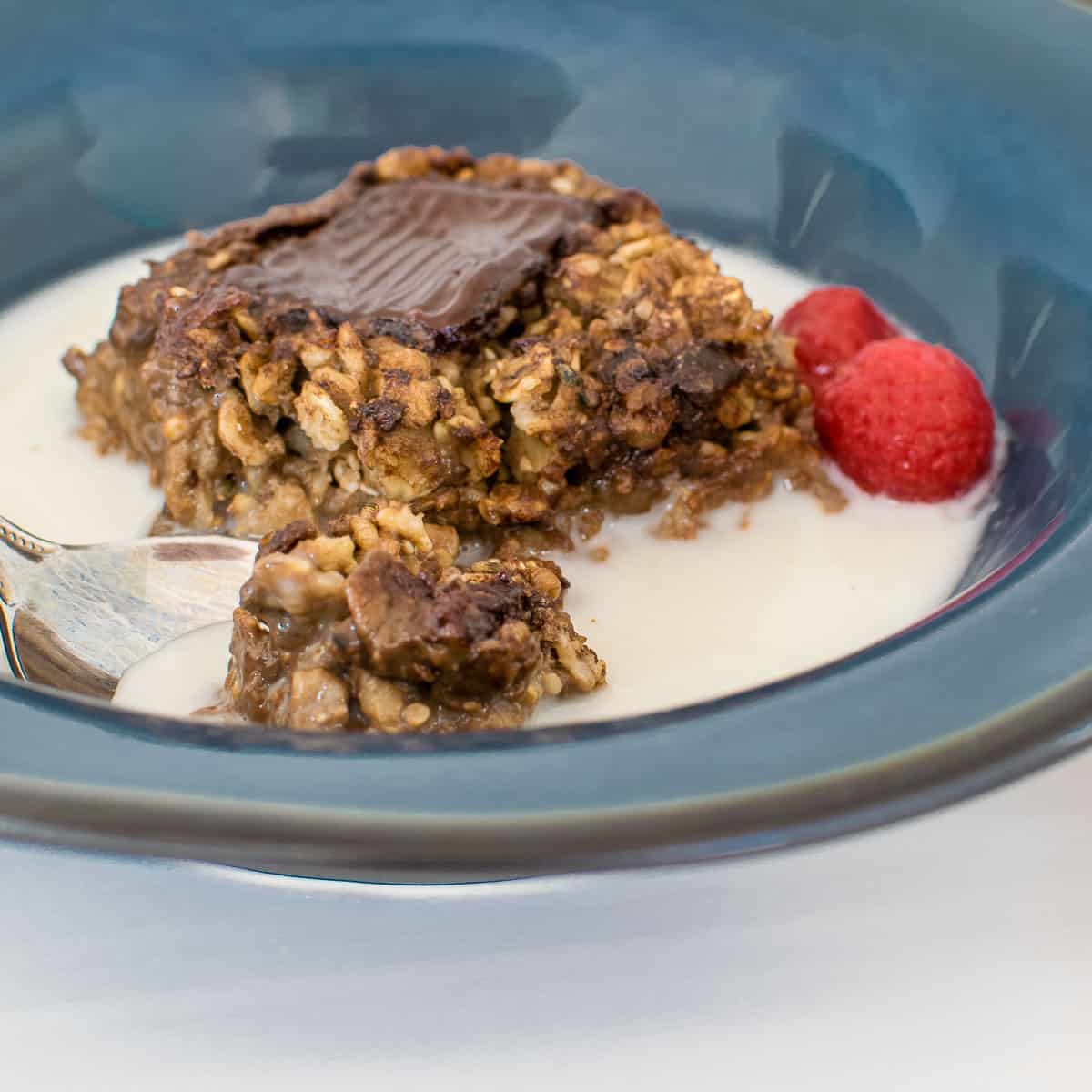 a spoon with a bite of served vegan chocolate baked oats. 