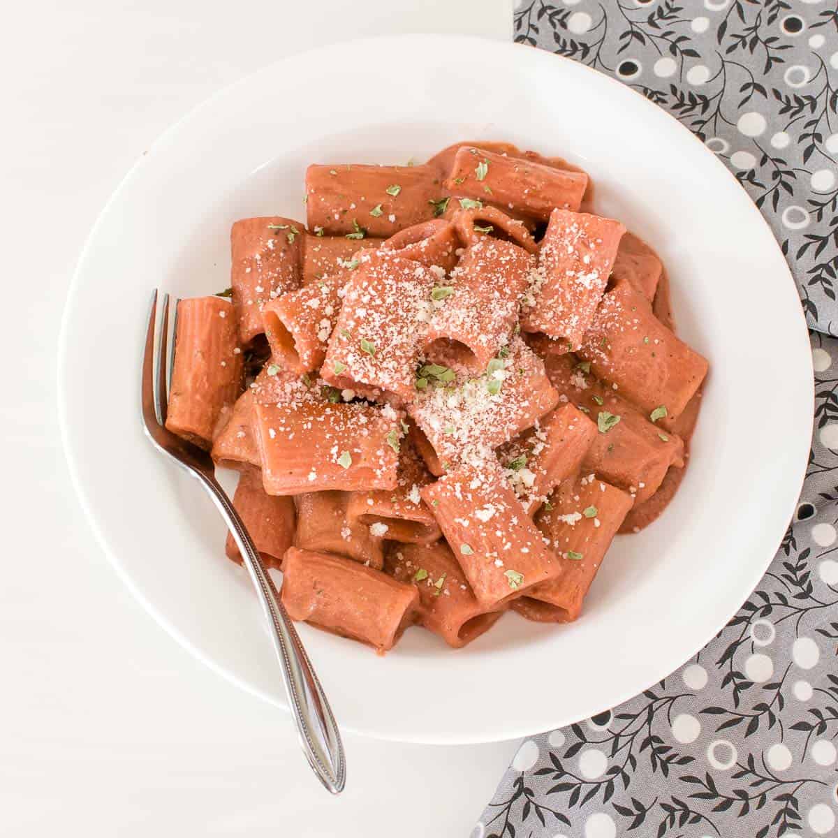 top view of served beetroot pink sauce pasta with garnishes. 