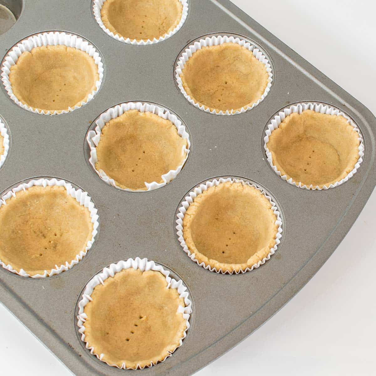 shaped tart shells in the muffin tray.