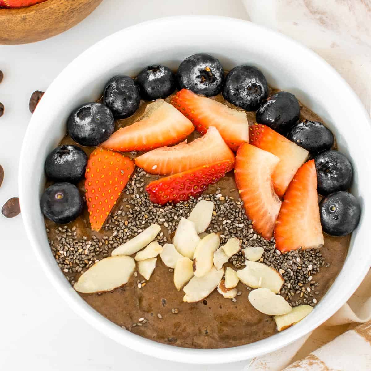 top close up view of garnished coffee smoothie bowl with toppings.