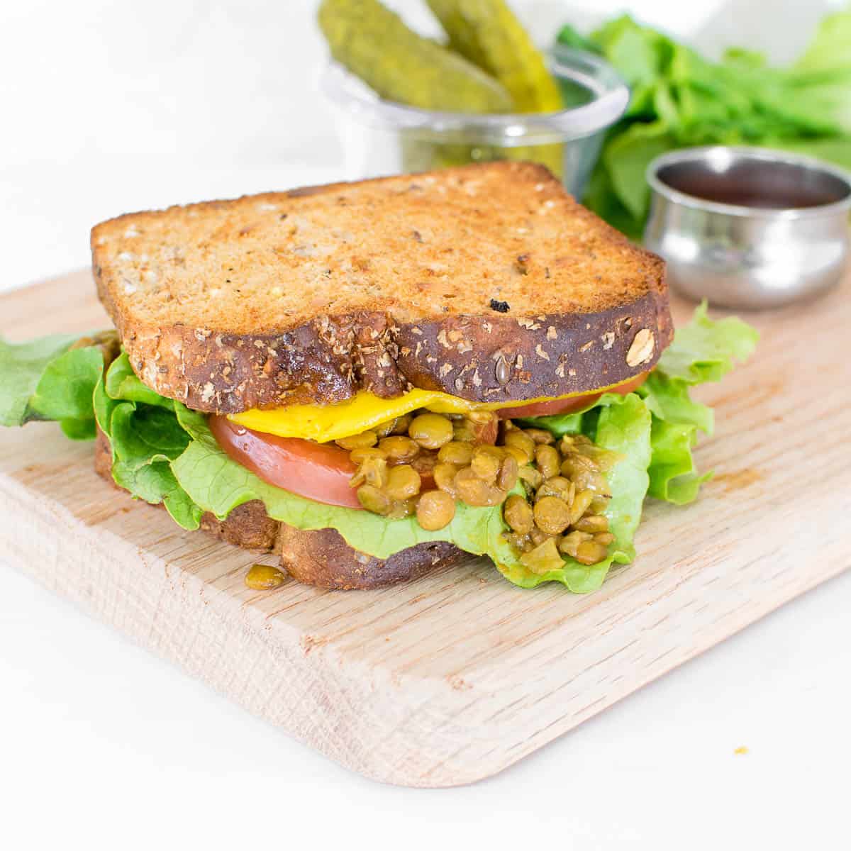 front view of assembled lentil sandwich on a wooden board.